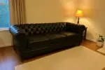 Chesterfield Sofa Black shown in a realistic home living room setting