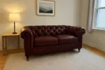 Chesterfield Sofa Loveseat Burgundy shown in a realistic home living room setting